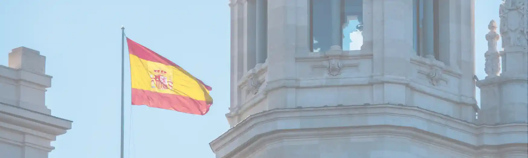 3 bürokratischen Hürden für deine Auswanderung nach Spanien - Fahne von Spanien vor dem Gebäude